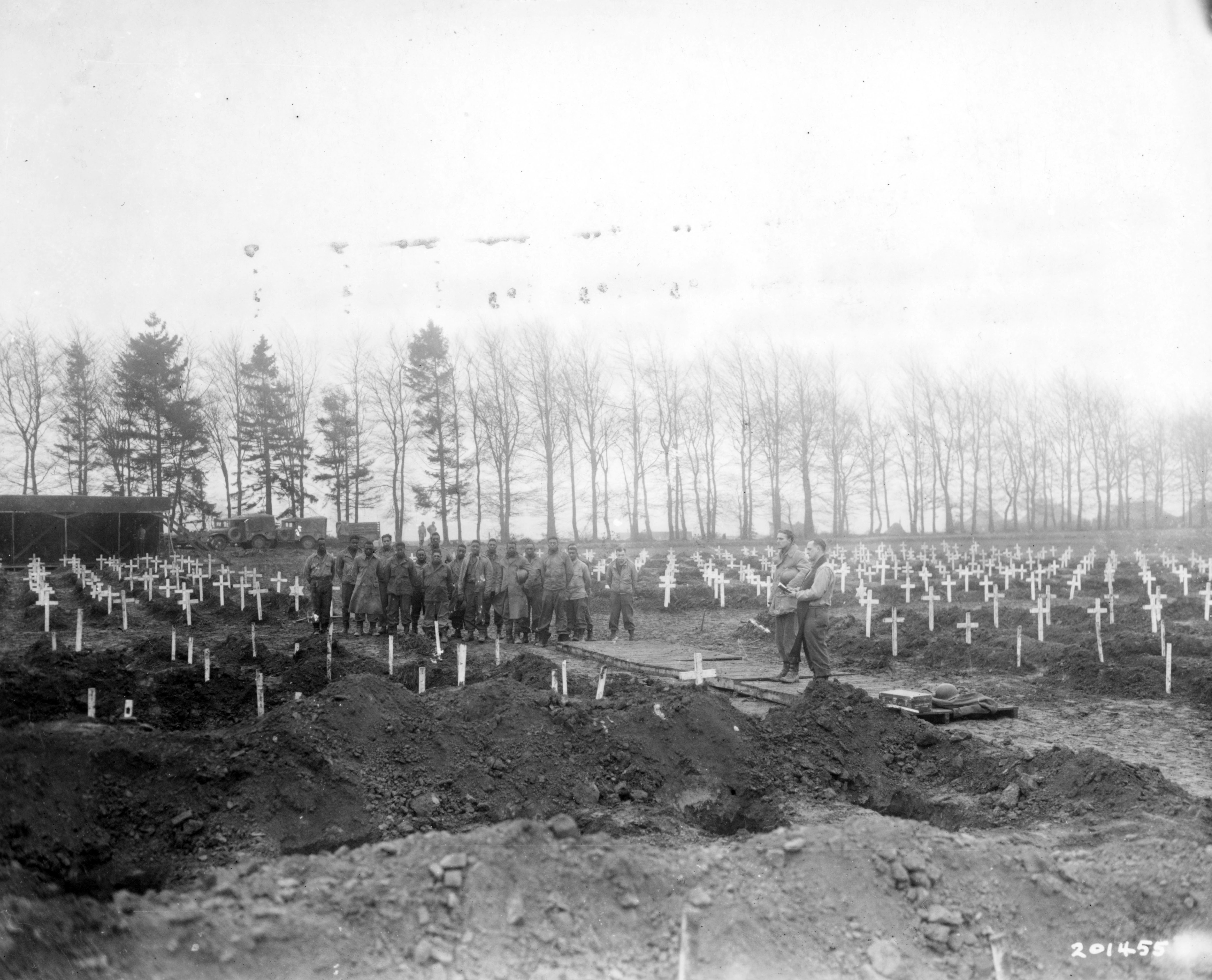 Historical image showing Capt. Cleetus C. Clemens conducts services at U.S. Military Cemetery No. 1 in Foy, Belgium. of Black American soldiers during WWII