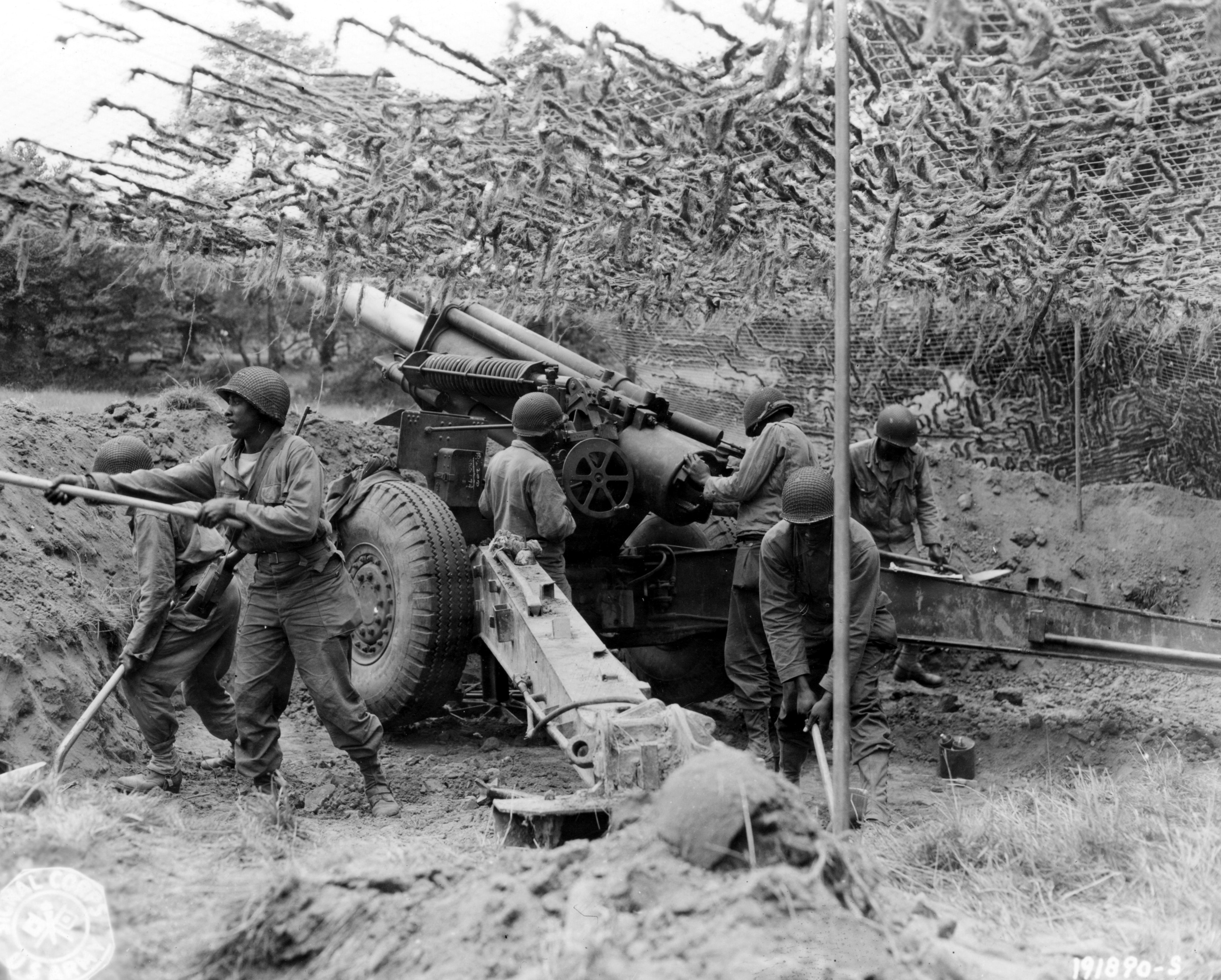 Historical image showing Black troops of a field artillery battery emplace a 155mm howitzer in France. of Black American soldiers during WWII