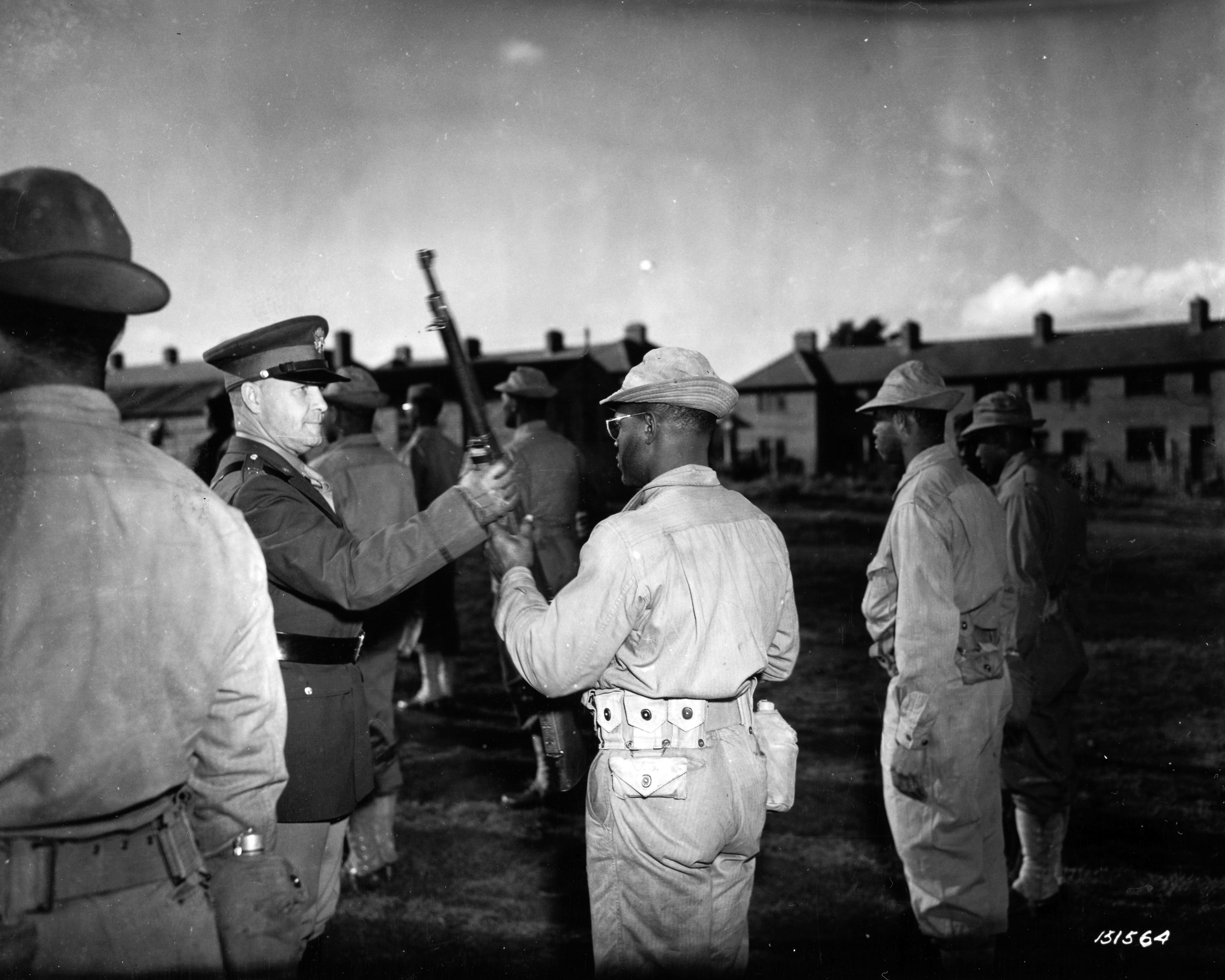 Historical image showing Major General John C.H. Lee during an inspection tour of Black troops somewhere in England. of Black American soldiers during WWII
