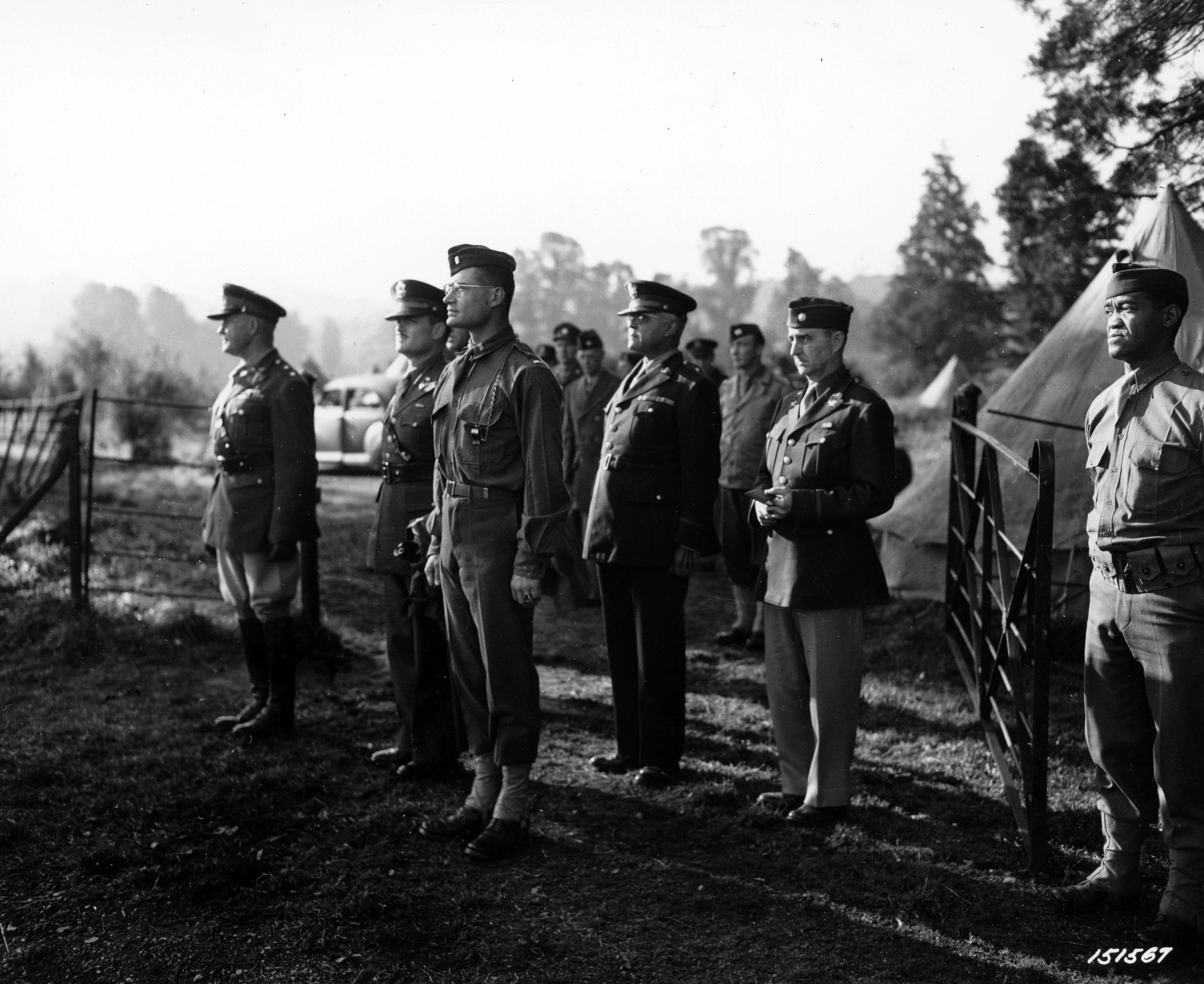 Historical image showing Major General John C.H. Lee and Brig. General Benjamin O. Davis inspect Services of Supply troops somewhere in England. of Black American soldiers during WWII