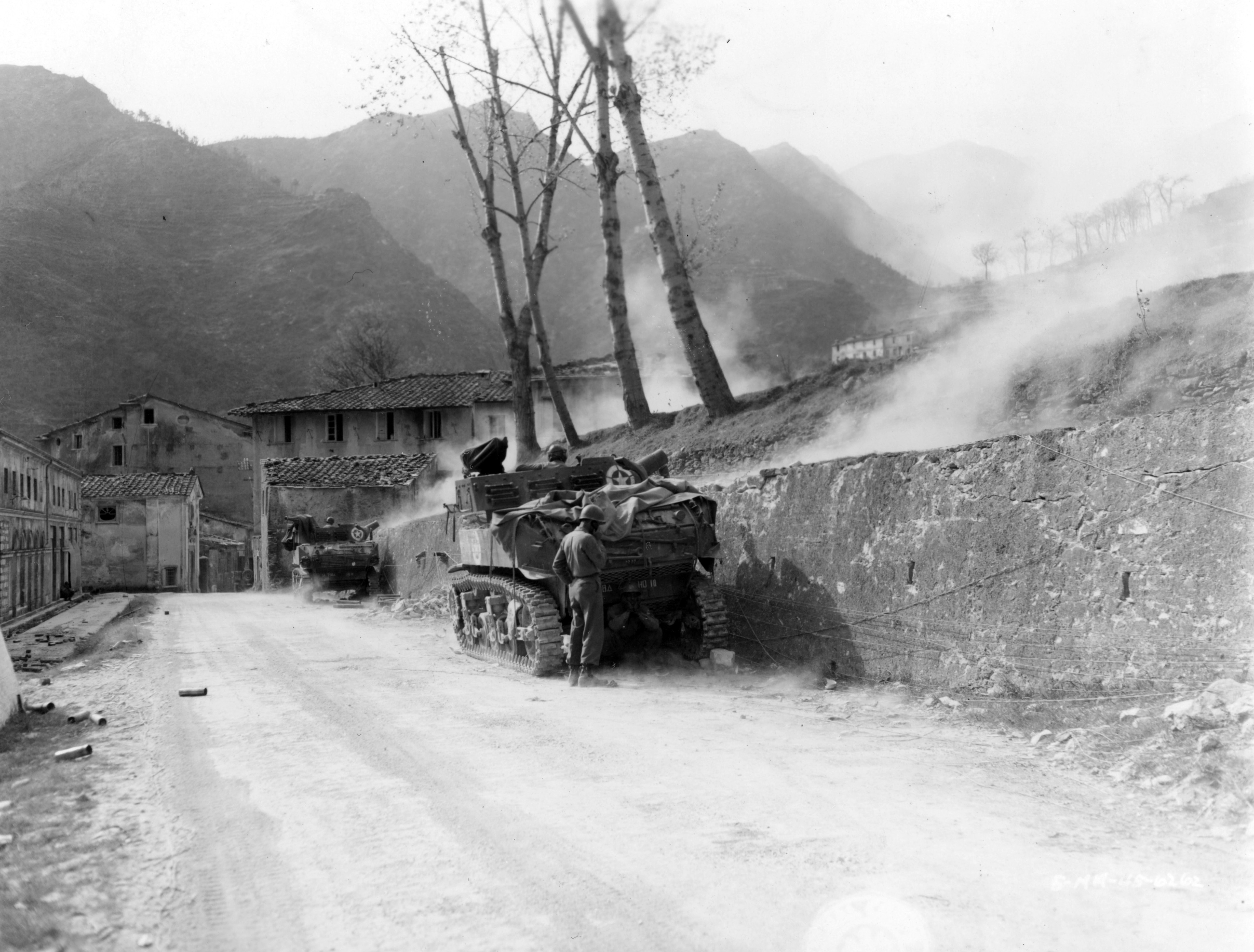Historical image showing Tanks of the 758th Light Tank Battalion fire in support as the Nisei regiment pushes on Mt. Belvedere. of Black American soldiers during WWII