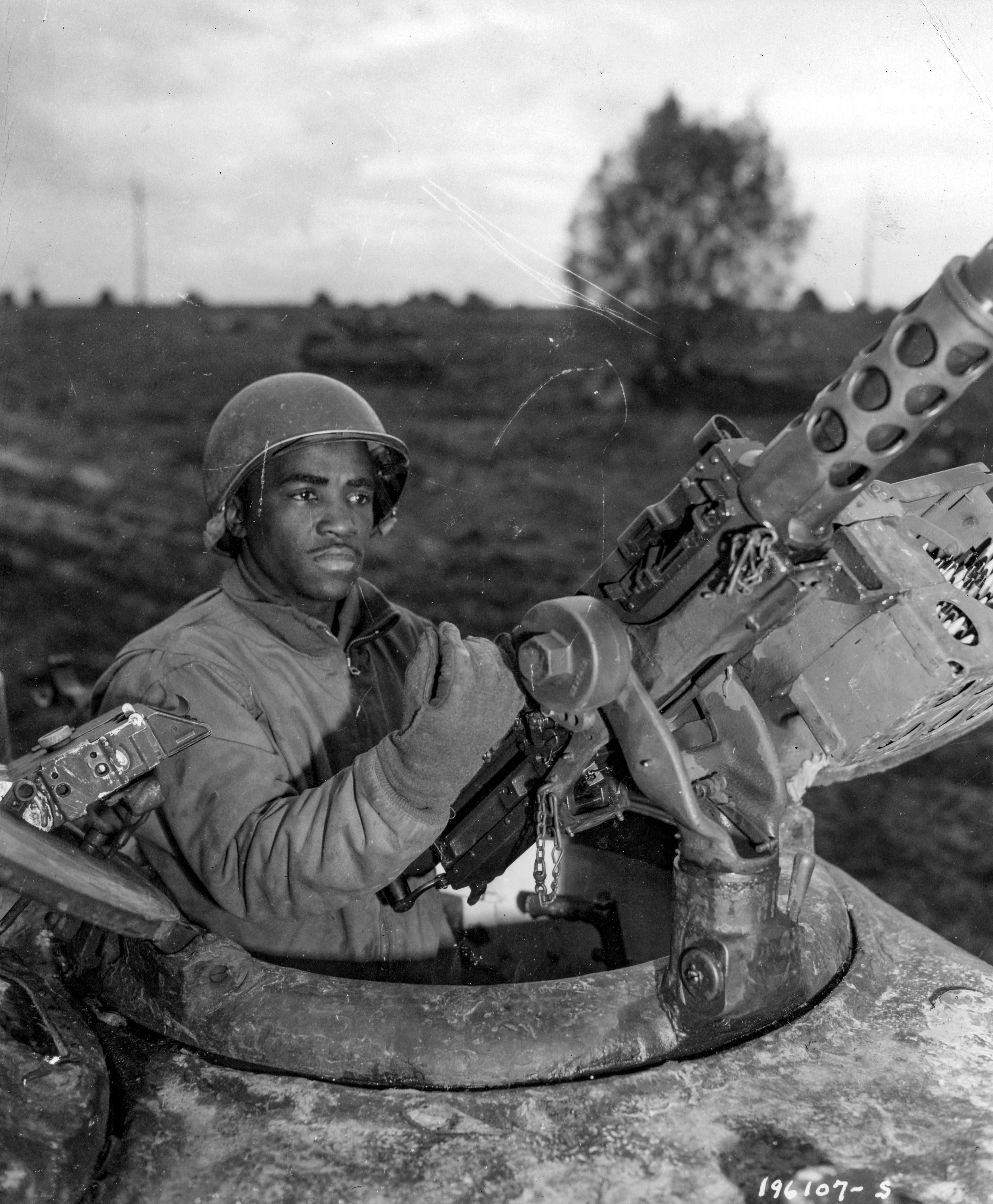 Historical image showing Corporal Carlton Chapman, Pembroke, Va., is a machine gunner in an M4 tank attached to a Motor Transport unit near Nancy, France. of Black American soldiers during WWII