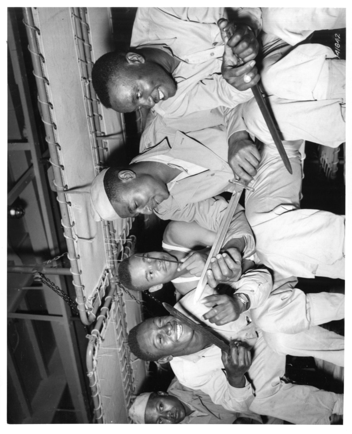 Historical image showing Soldiers of the 76th Coast Artillery Regiment are looking at their bayonets of Black American soldiers during WWII
