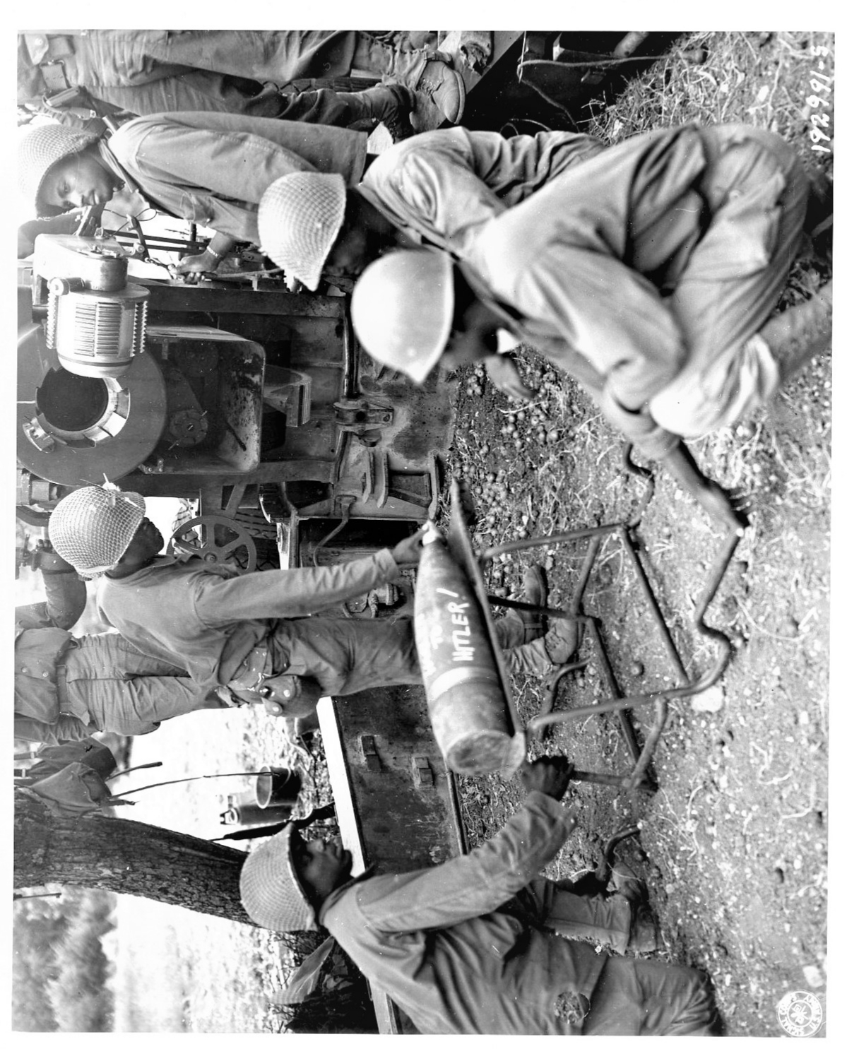 Historical image showing Soldiers of the 999th Field Artillery Battalion are about to fire another shell at a target. of Black American soldiers during WWII