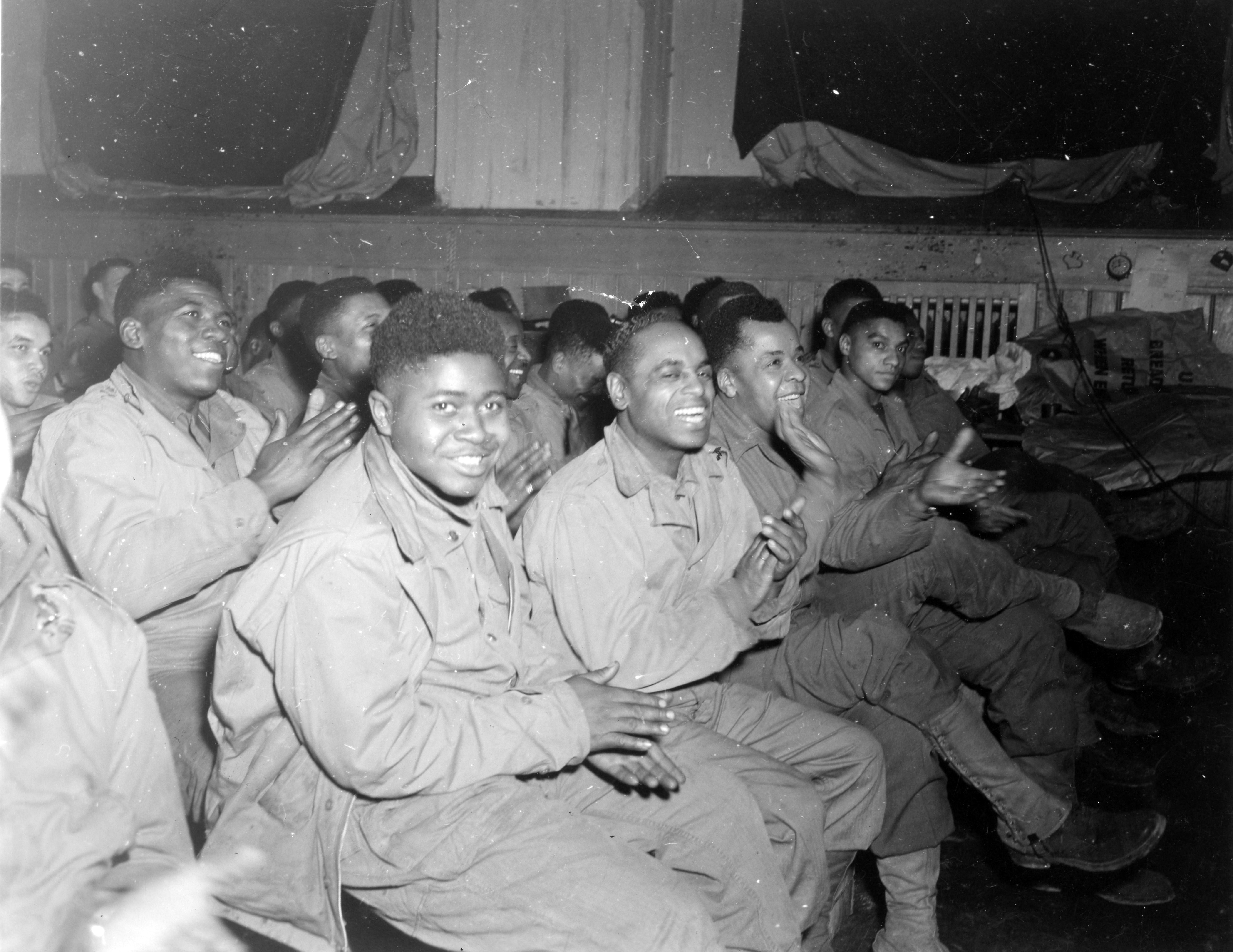 Historical image showing Part of audience enjoying all-soldier entertainment near VII headquarters in Germany, sponsored by Quartermaster troops. of Black American soldiers during WWII
