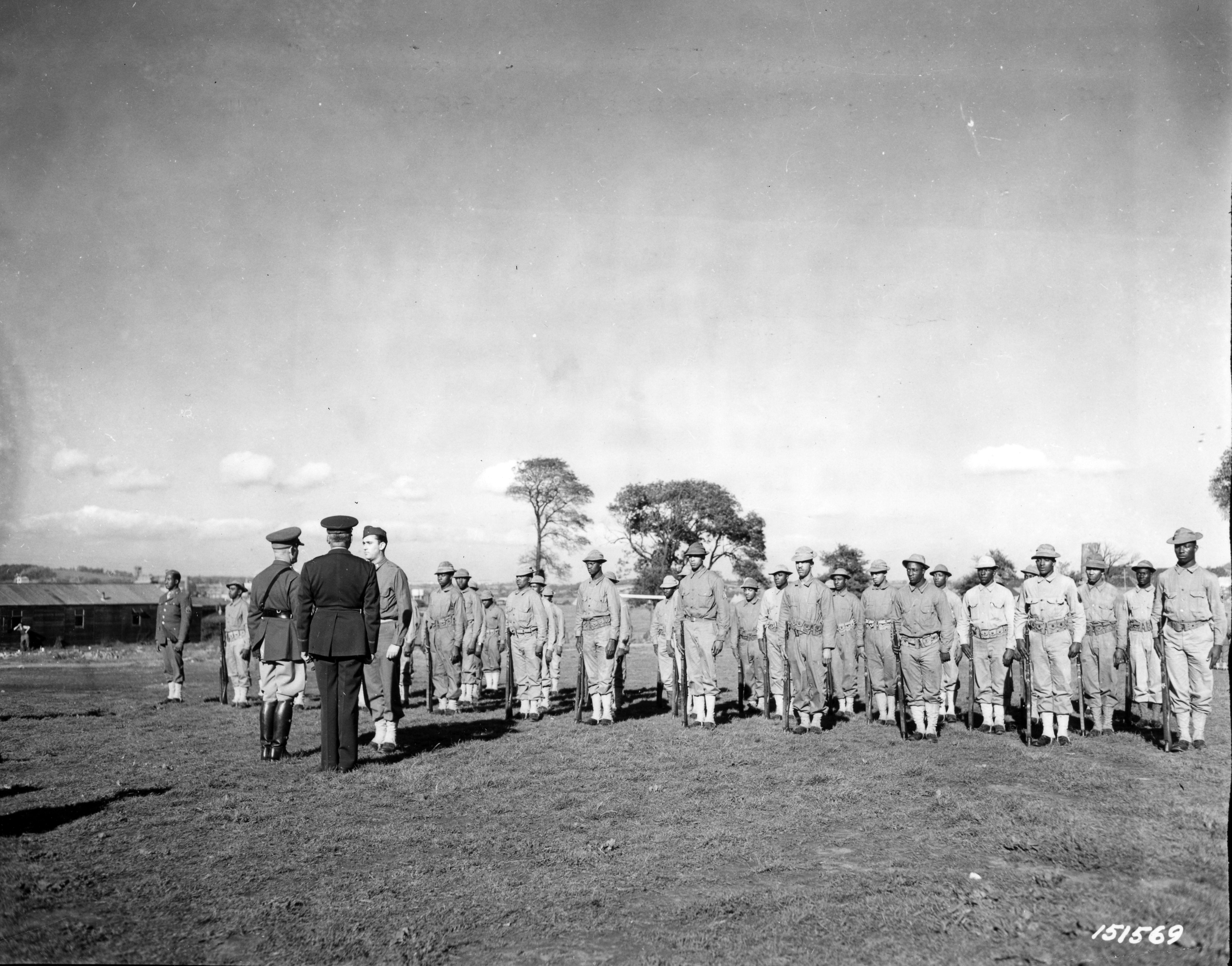 Historical image showing Brig. General Benjamin O. Davis and Maj. General John C.H. Lee inspect Black troops. of Black American soldiers during WWII