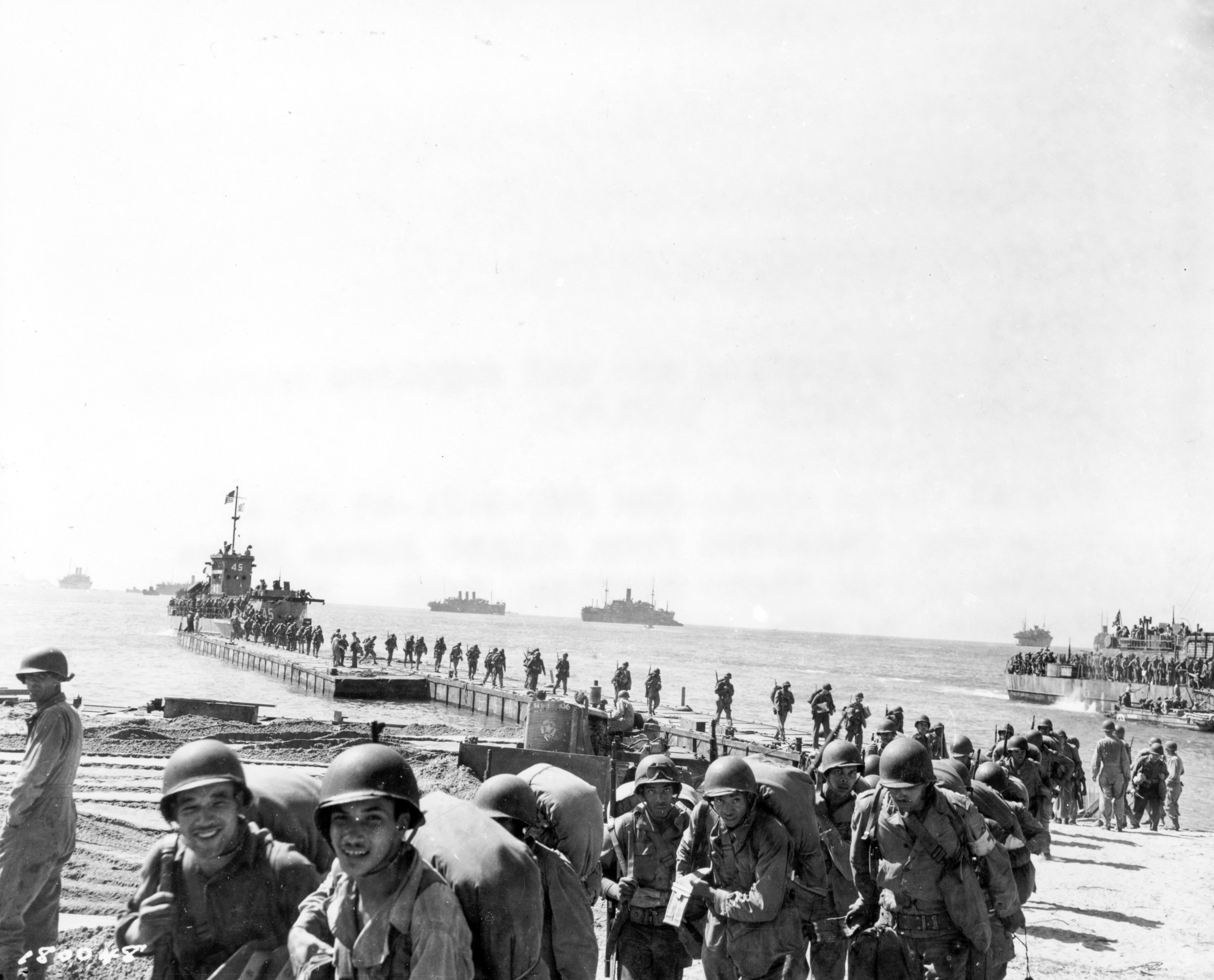Historical image showing A convoy unloading men and supplies north of Agropoli, Italy. of Black American soldiers during WWII
