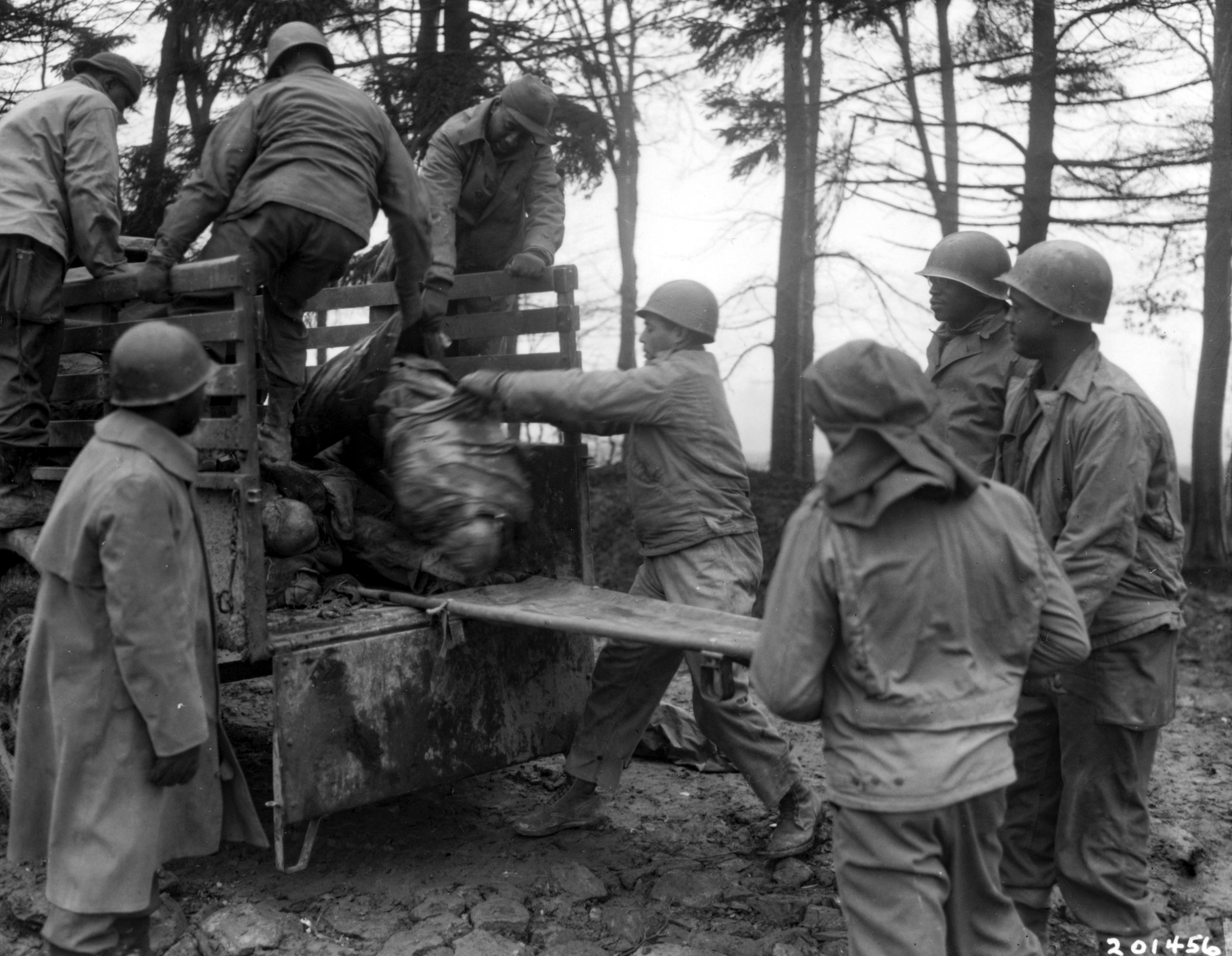 Historical image showing U.S. casualties on the Third Army front are unloaded for burial at U.S. Military Cemetery in Foy, Belgium. of Black American soldiers during WWII
