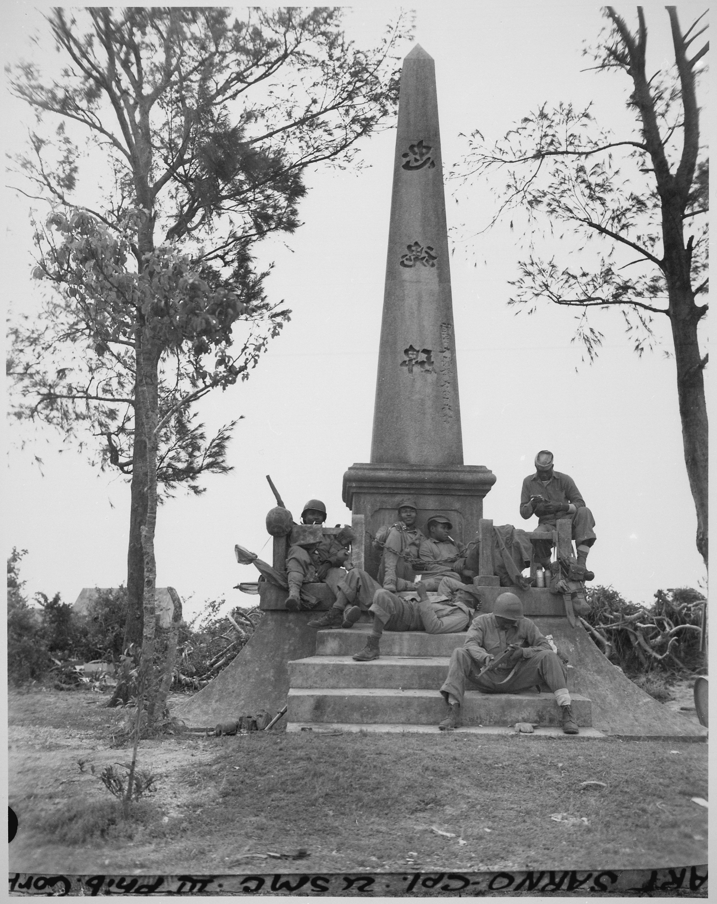 Historical image showing Marines resting at a Japanese memorial. of Black American soldiers during WWII