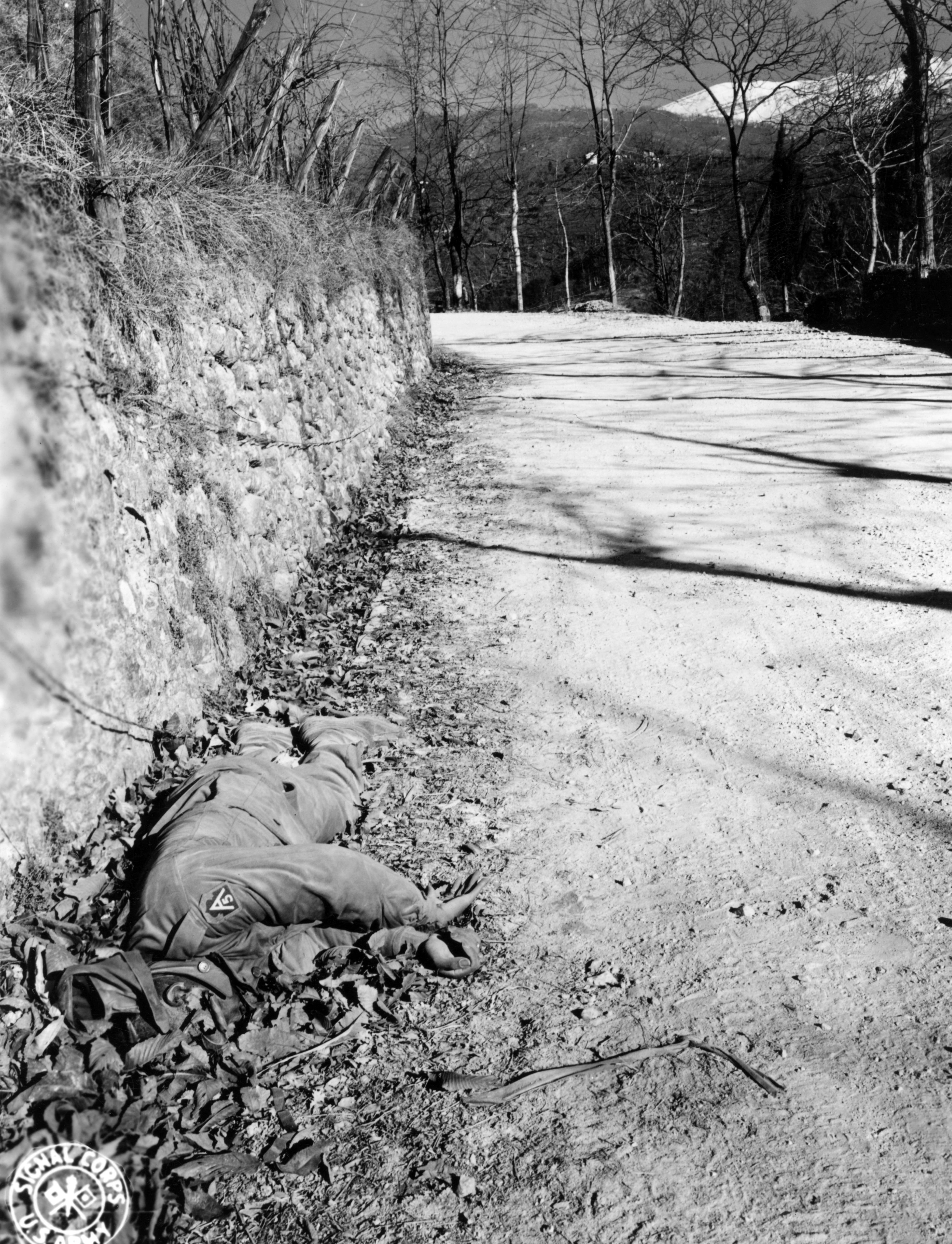 Historical image showing The body of a dead Black soldier bears mute testimony to the force of the German drive down the Serchio Valley. of Black American soldiers during WWII