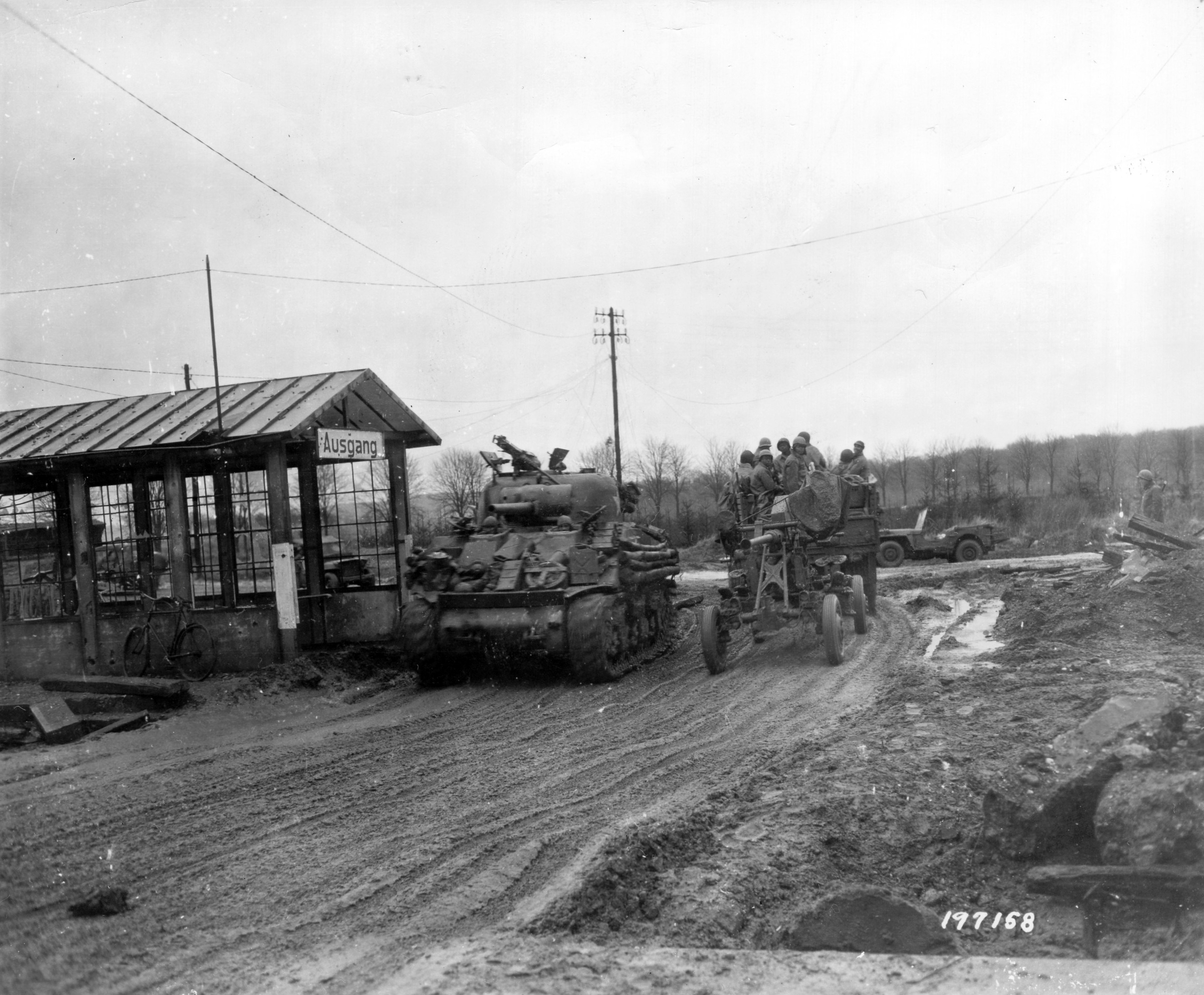 Historical image showing A newly captured crossroad carries east and west bound traffic as Lt. General George S. Patton's Third Army smashes towards the Rhine. of Black American soldiers during WWII